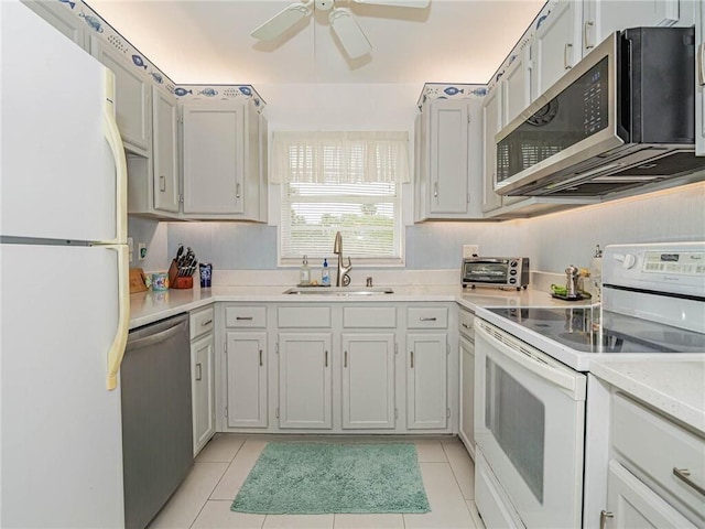 kitchen with ceiling fan, light tile patterned flooring, stainless steel appliances, a sink, and light countertops