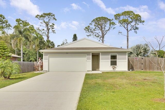 view of front facade with a front yard, driveway, an attached garage, and fence