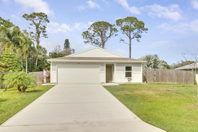 view of front of house with driveway, a garage, fence, and a front yard