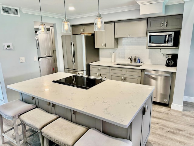 kitchen featuring stainless steel appliances, a sink, visible vents, ornamental molding, and gray cabinets