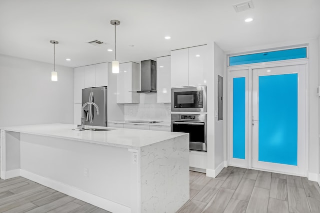 kitchen with visible vents, wall chimney exhaust hood, modern cabinets, stainless steel appliances, and white cabinetry