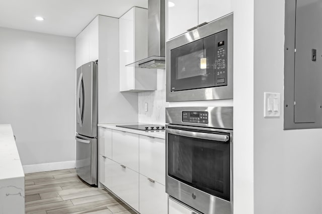 kitchen featuring wall chimney range hood, modern cabinets, and stainless steel appliances