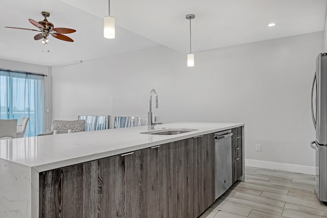 kitchen with dark brown cabinetry, baseboards, modern cabinets, appliances with stainless steel finishes, and a sink