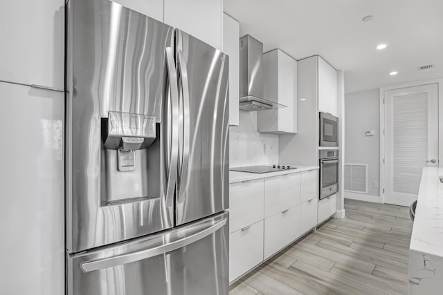 kitchen featuring wall chimney exhaust hood, appliances with stainless steel finishes, modern cabinets, and white cabinets