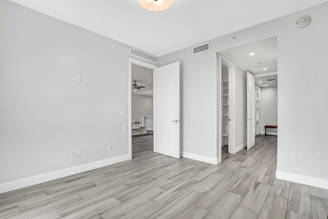 empty room with baseboards, visible vents, and wood tiled floor