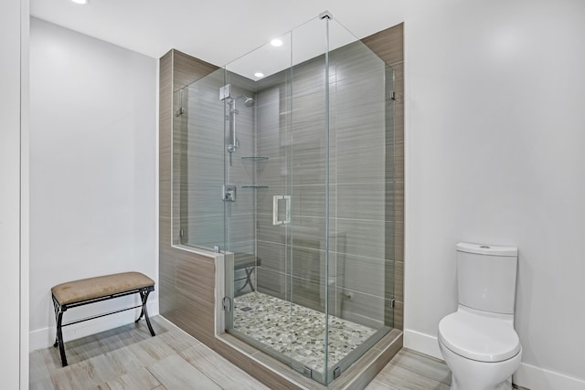 full bathroom featuring a shower stall, toilet, and baseboards