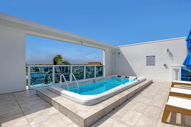 view of pool with hot tub deck surround