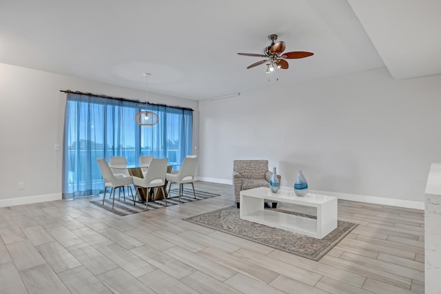 sitting room with a ceiling fan, wood tiled floor, and baseboards