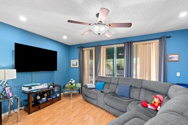 living room with a textured ceiling, wood finished floors, a ceiling fan, and recessed lighting