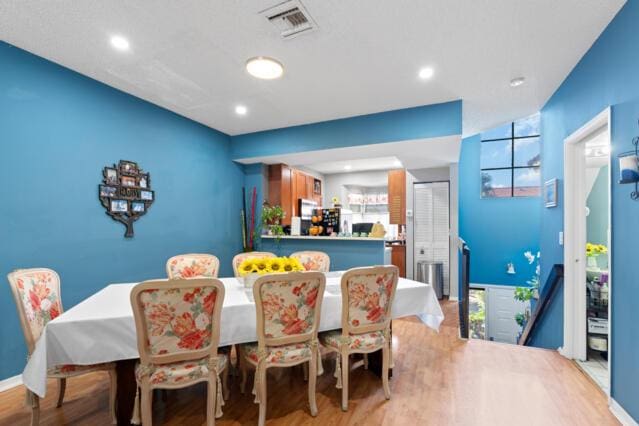 dining space featuring baseboards, wood finished floors, visible vents, and recessed lighting