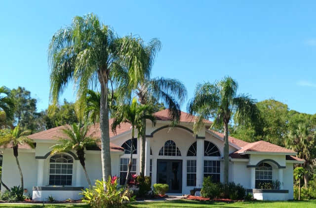 mediterranean / spanish home with a front yard and stucco siding