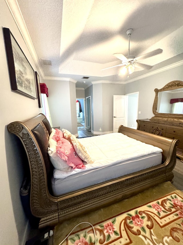 bedroom featuring ceiling fan, a textured ceiling, and crown molding