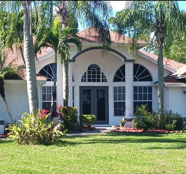 exterior space with a lawn and stucco siding