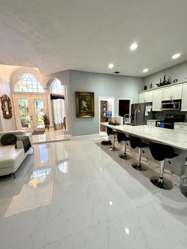 office featuring marble finish floor, french doors, a sink, and recessed lighting