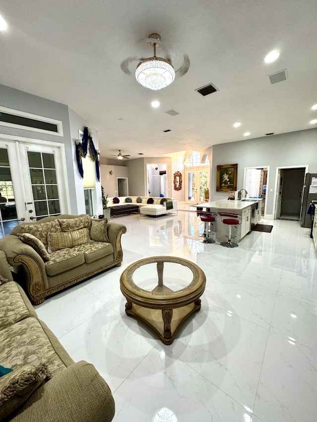 living area with marble finish floor, a ceiling fan, visible vents, and recessed lighting