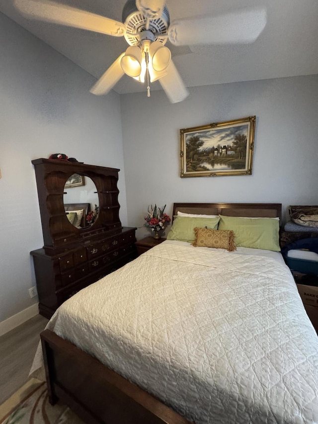 bedroom with wood finished floors, a ceiling fan, and baseboards