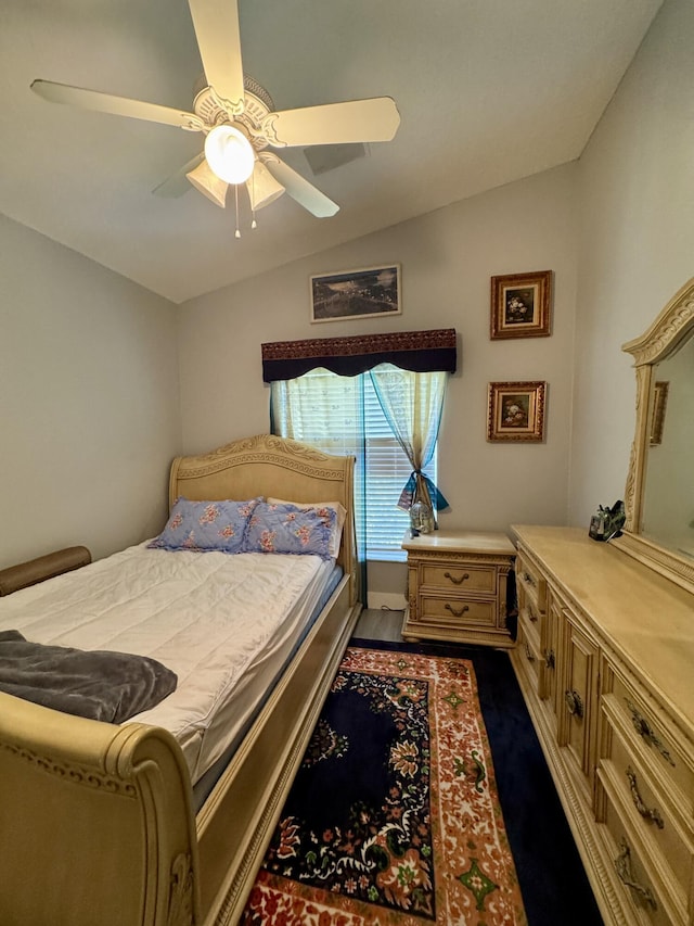 bedroom with a ceiling fan, lofted ceiling, and dark wood-type flooring