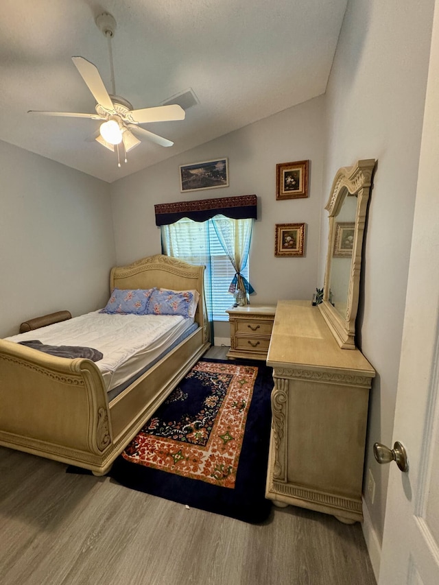 bedroom featuring lofted ceiling, a ceiling fan, and wood finished floors