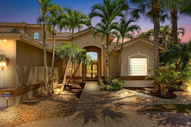 exterior space featuring french doors, a tiled roof, and stucco siding