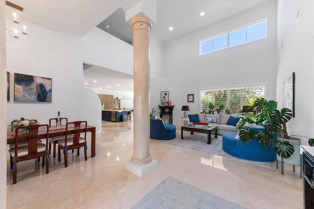 living area with marble finish floor, a high ceiling, and decorative columns