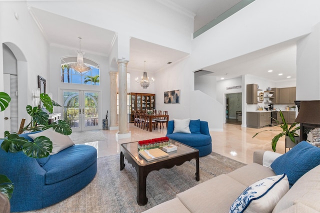 living area featuring french doors, decorative columns, a high ceiling, ornamental molding, and baseboards