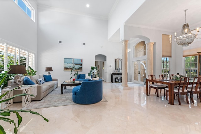 living area with crown molding, a healthy amount of sunlight, and ornate columns