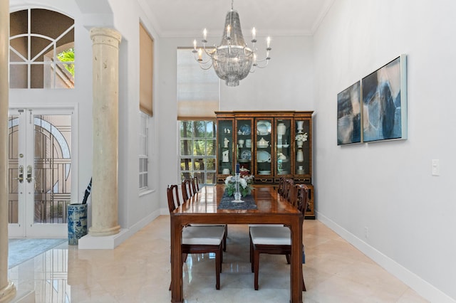 dining area with decorative columns, a towering ceiling, crown molding, french doors, and a chandelier