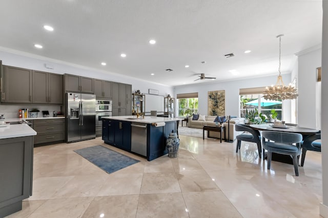 kitchen featuring stainless steel appliances, a kitchen island with sink, recessed lighting, crown molding, and light countertops