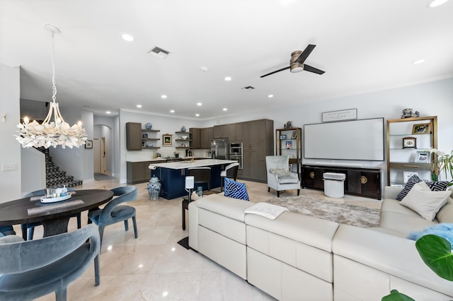 living area featuring recessed lighting, visible vents, and ceiling fan with notable chandelier