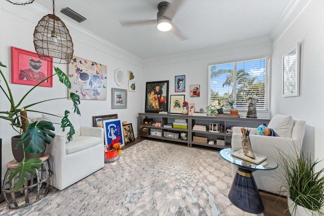 sitting room featuring visible vents, a ceiling fan, and ornamental molding