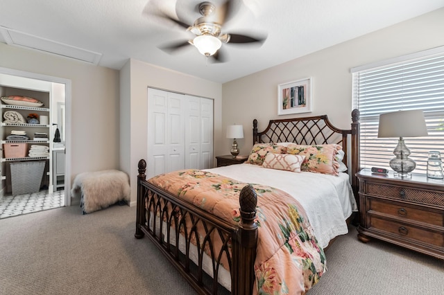 carpeted bedroom featuring attic access, a ceiling fan, and a closet