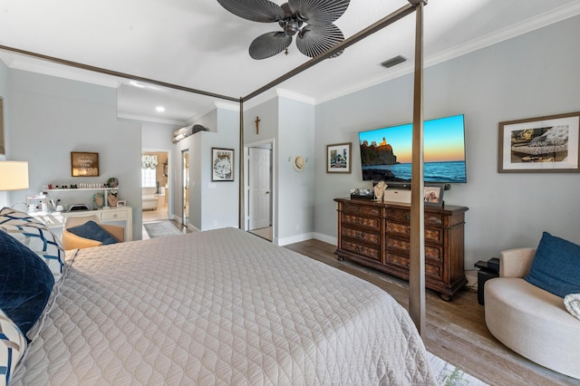 bedroom featuring ensuite bathroom, wood finished floors, visible vents, baseboards, and ornamental molding