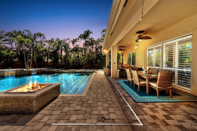 outdoor pool featuring a patio area, a fire pit, and a ceiling fan