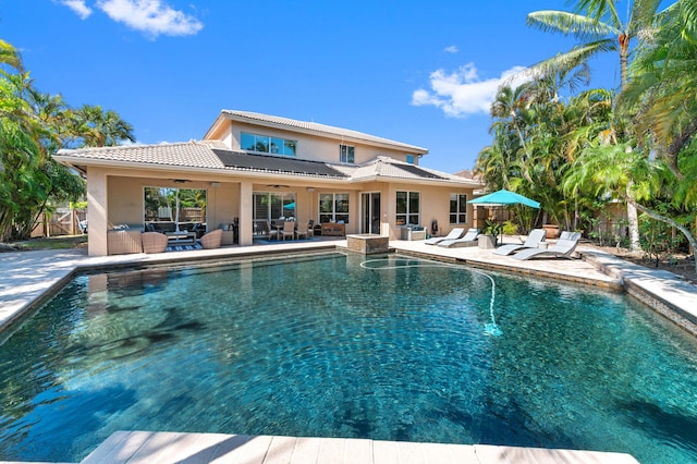 view of swimming pool with ceiling fan, a patio, a fenced backyard, and an outdoor living space