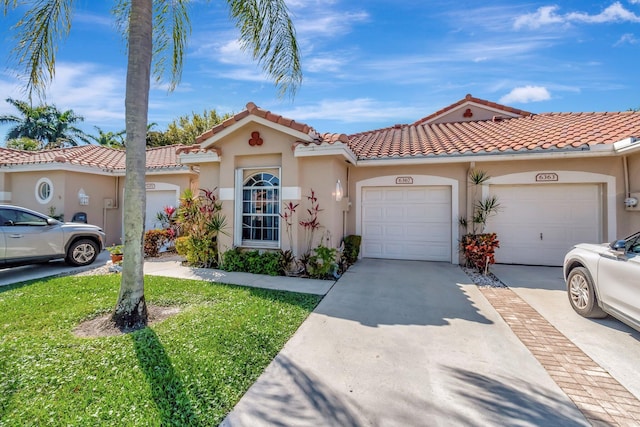 view of front of home featuring concrete driveway, a tiled roof, and stucco siding