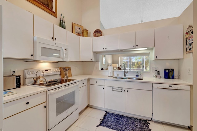 kitchen with white appliances, light countertops, a sink, and light tile patterned floors