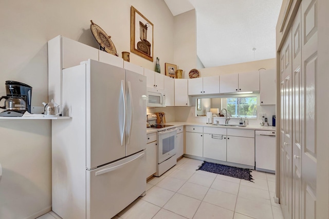 kitchen with light tile patterned floors, lofted ceiling, white appliances, a sink, and light countertops