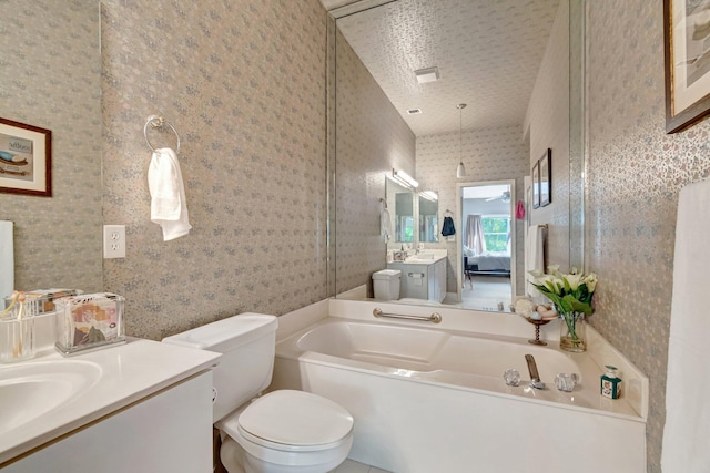 bathroom with toilet, vanity, a bath, and wallpapered walls