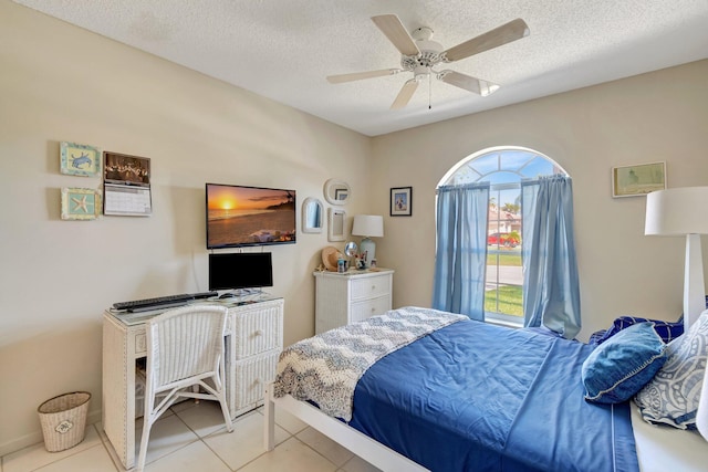 bedroom with a ceiling fan, a textured ceiling, and light tile patterned floors