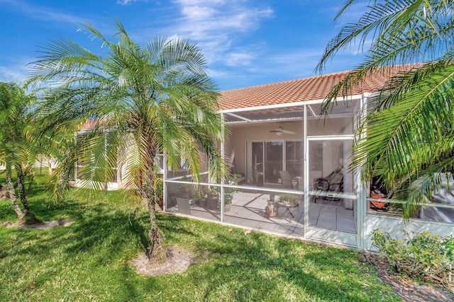 6367 Long Key Ln, Boynton Beach, FL 33472 - rear view of property with a tiled roof, a sunroom, a ceiling fan, a yard, and stucco siding