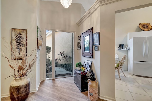 entrance foyer with baseboards, light wood finished floors, and a notable chandelier