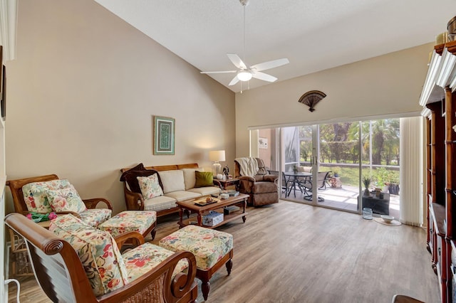 living area featuring ceiling fan, high vaulted ceiling, and wood finished floors