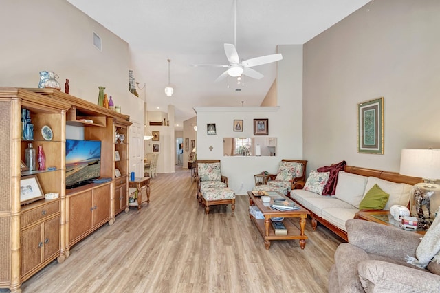 living area featuring high vaulted ceiling, light wood finished floors, visible vents, and a ceiling fan