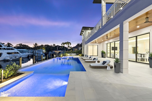 view of pool with a patio area, an infinity pool, and ceiling fan