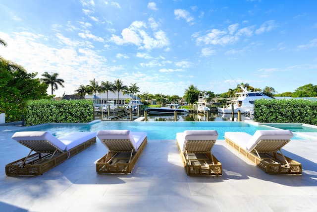 view of pool with a boat dock, a patio area, an infinity pool, and boat lift