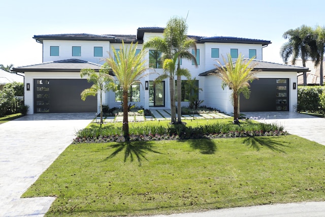 view of front facade featuring a front yard, a garage, and driveway