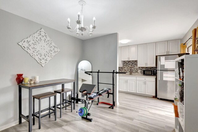 kitchen featuring under cabinet range hood, a sink, light countertops, appliances with stainless steel finishes, and decorative backsplash