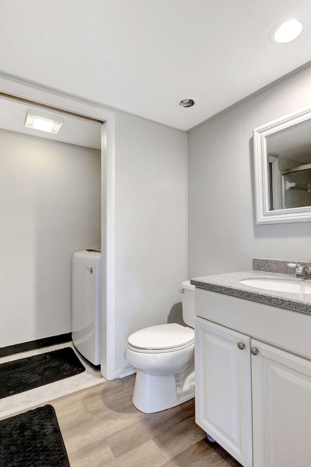 full bathroom featuring washer / clothes dryer, vanity, toilet, and wood finished floors