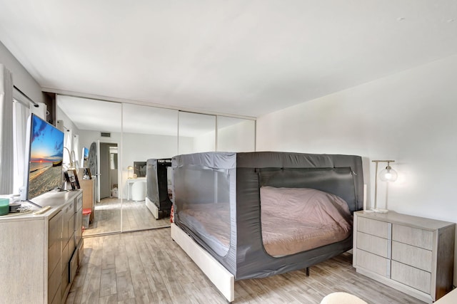 bedroom featuring light wood-type flooring and visible vents