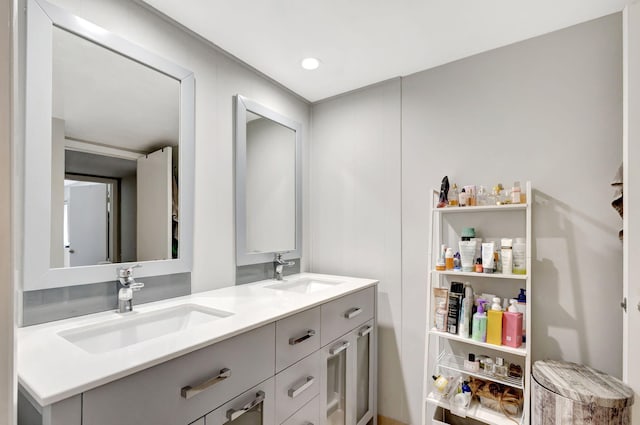 bathroom featuring double vanity, a sink, and recessed lighting